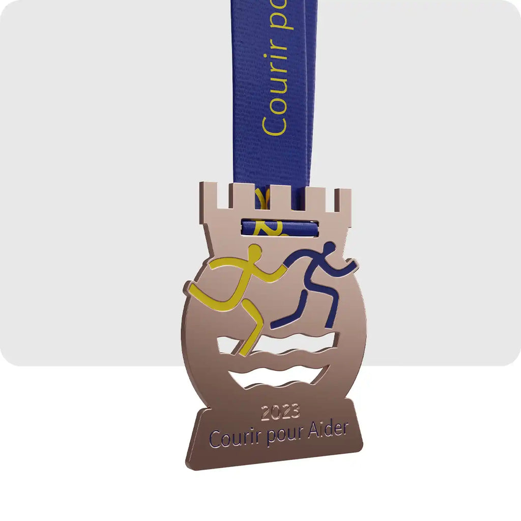 médaille gravé, donc la forme représente un château de couleur bronze ainsi que deux personnages abstrait qui courent main dans la main.