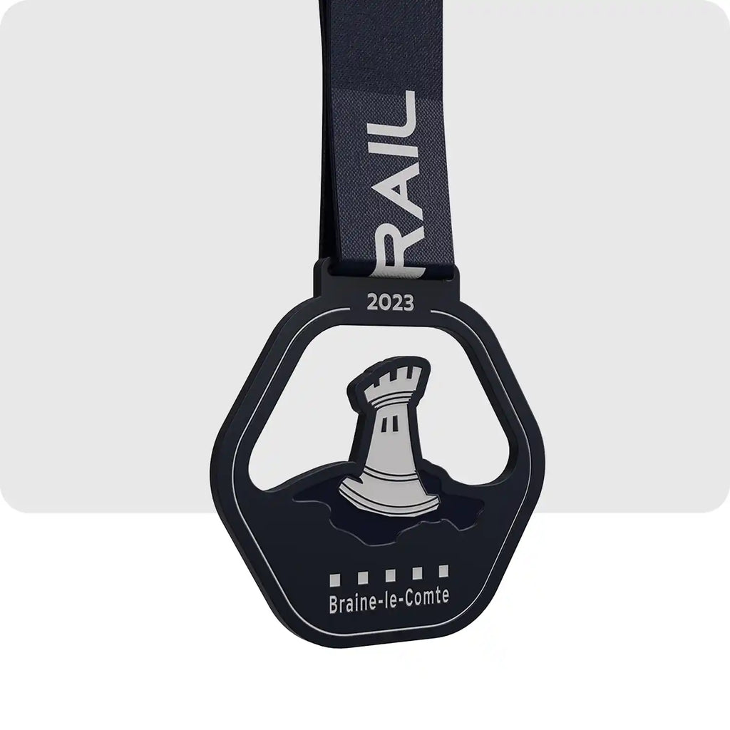 Médaille en métal de couleur noir contenant un château de couleur gris en son centre, pour le trail de la ville de "Braine-le-Comte".