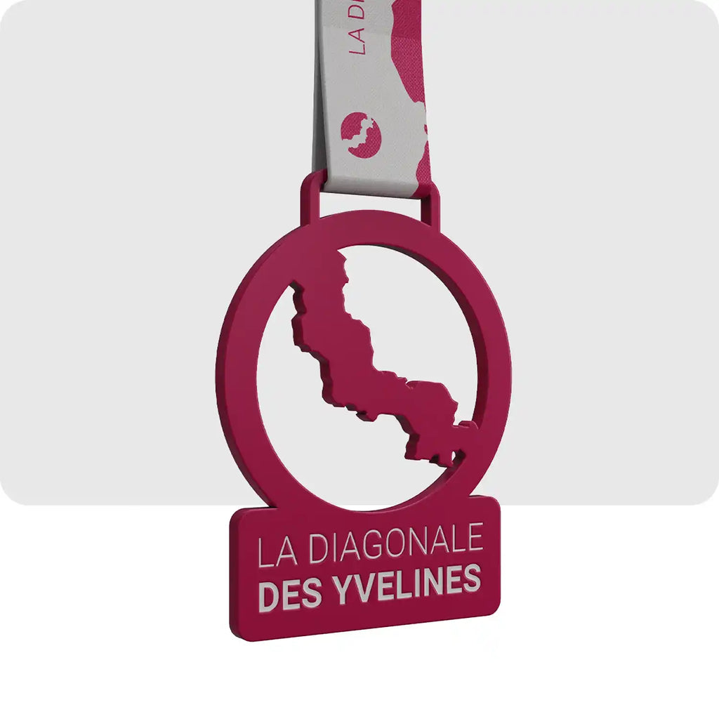 médaille gravée en métal de couleur rouge en forme de cercle, ce même cercle est barré en diagonale par une sorte de forme abstraite.
