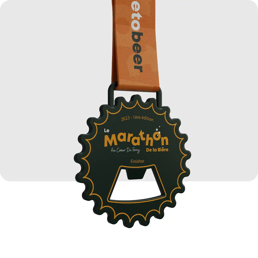 Médaille gravée de couleur vert très foncé, ces contours, sa forme représente un décapsuleur de bière. Et au centre, le nom de la course apparait en orange. 
