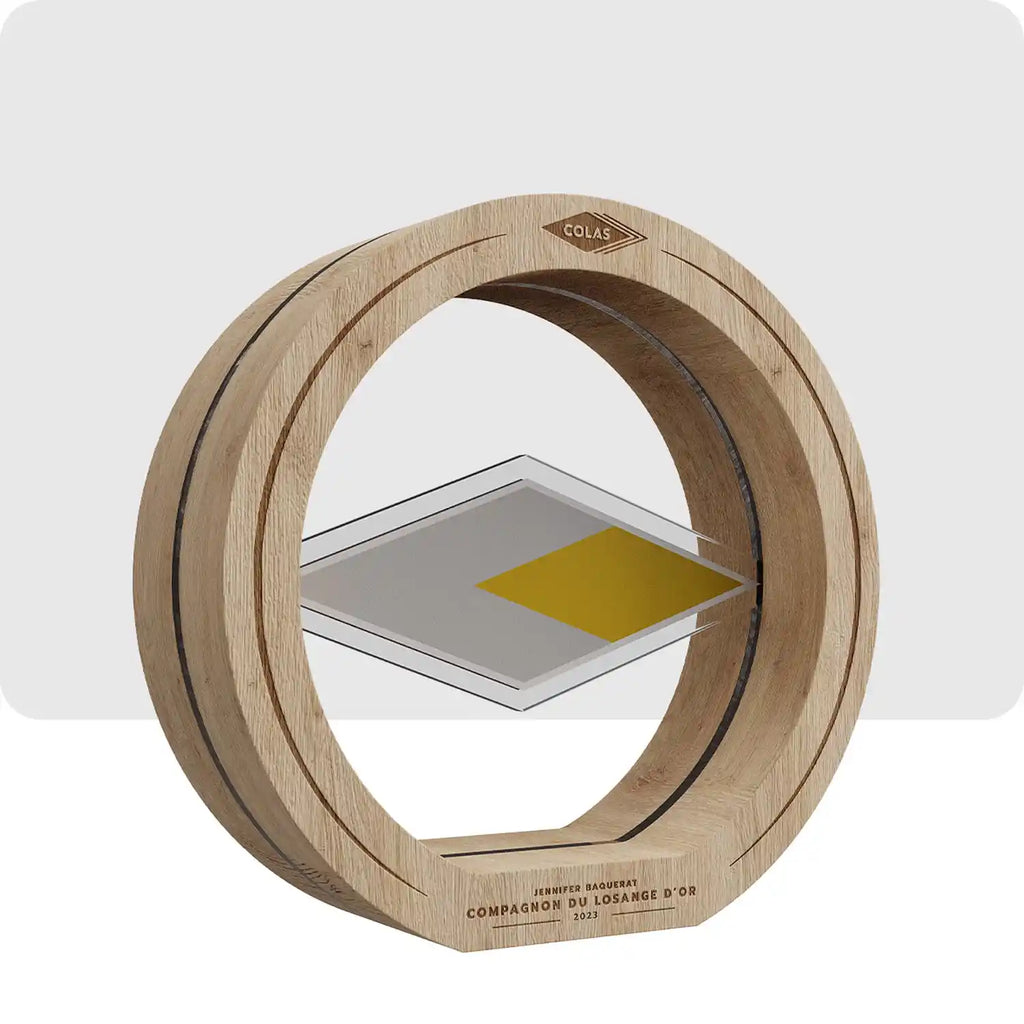 Trophée personnalisé en bois et plexiglass, le contour est rond et en bois, au centre le plexiglass est en forme de losange de couleur gris est jaune.  