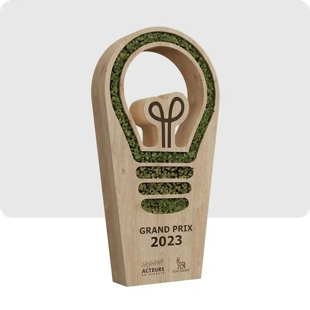 Trophée personnalisé en bois avec des incrustations végétales, le trophée est en forme d'ampoule. 