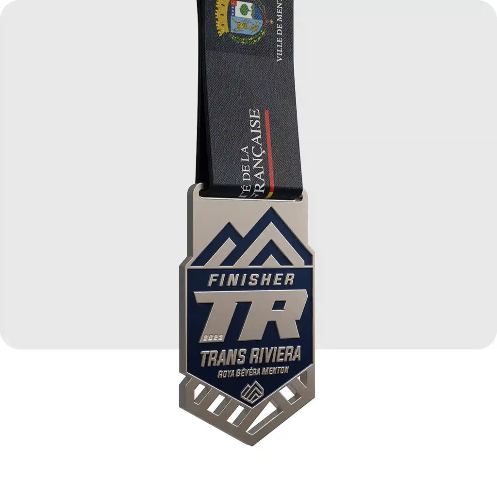 Médaille gravé, en métal, de couleur argenté et bleu marine.  Avec les inscriptions du nom de la course ainsi que le mot "Finisher".