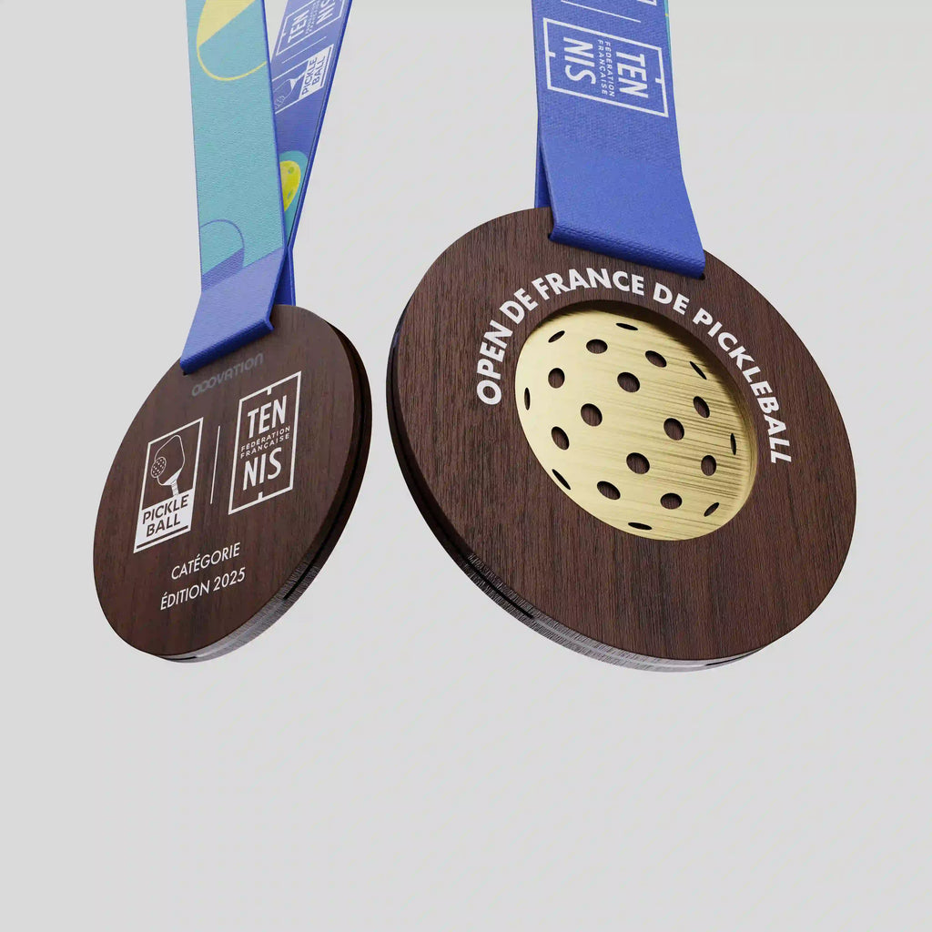 Médaille en bois foncé avec balle ajourée dorée pour l’Open de France de Pickleball.