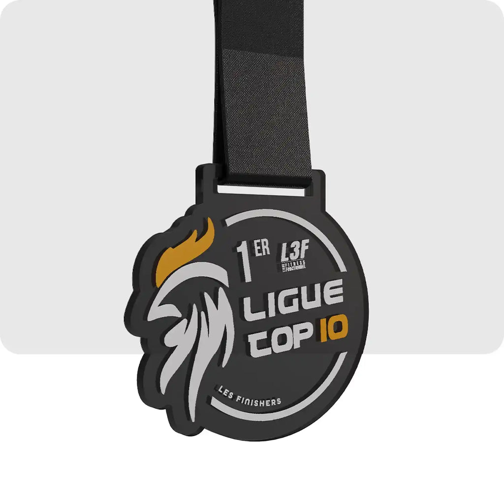 médaille en plastique de finisher de couleur noir, grise et orange. Avec sur la gauche la tête d'un coque stylisé 