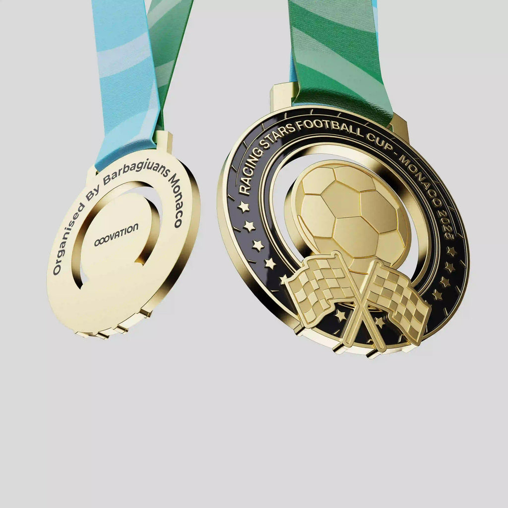 médaille en métal noir et or avec un ballon de football et des drapeaux de circuits