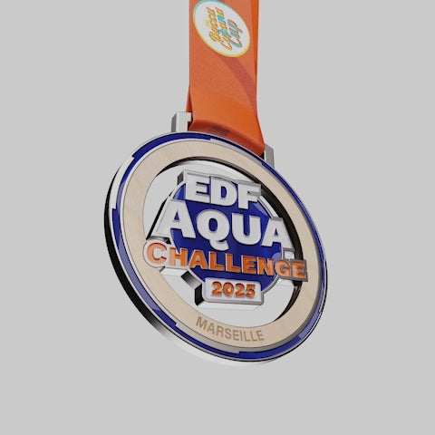 vidéo de la Médaille en bois et métal EDF Aqua Challenge 2025 à Marseille, avec ruban orange.