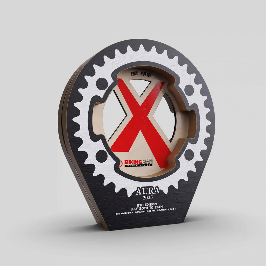 Trophée en bois BikingMan AURA 2025 en forme de pignon de vélo avec design ajouré et logo rouge.