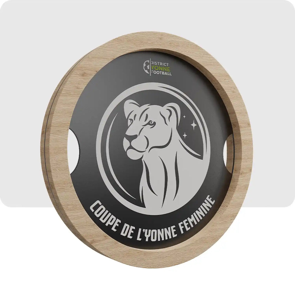 Trophée personnalisé en bois, en son centre il y a un cercle noir comprenant le logo de l'évènement. 
